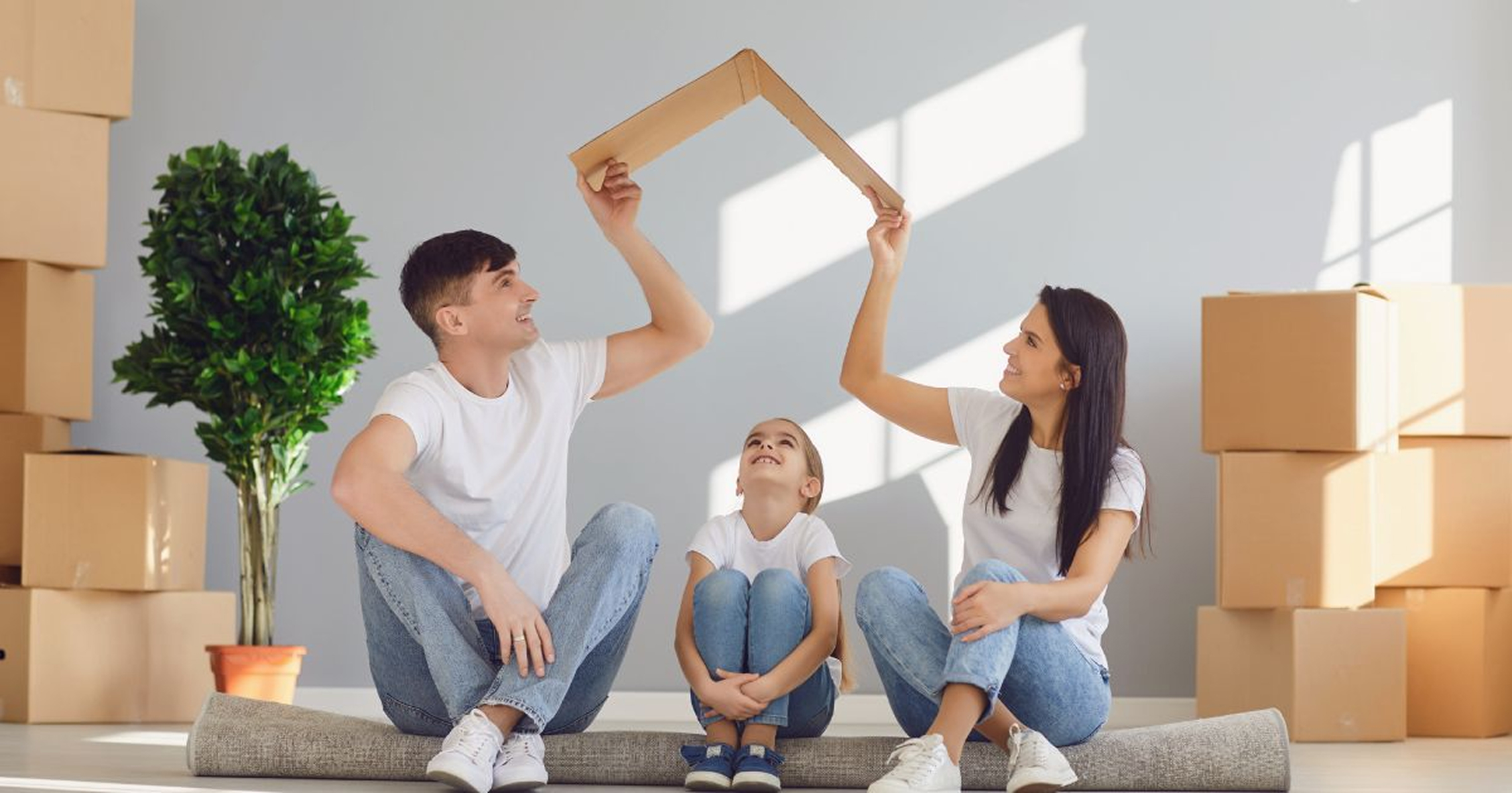Family holding a cardboard roof together